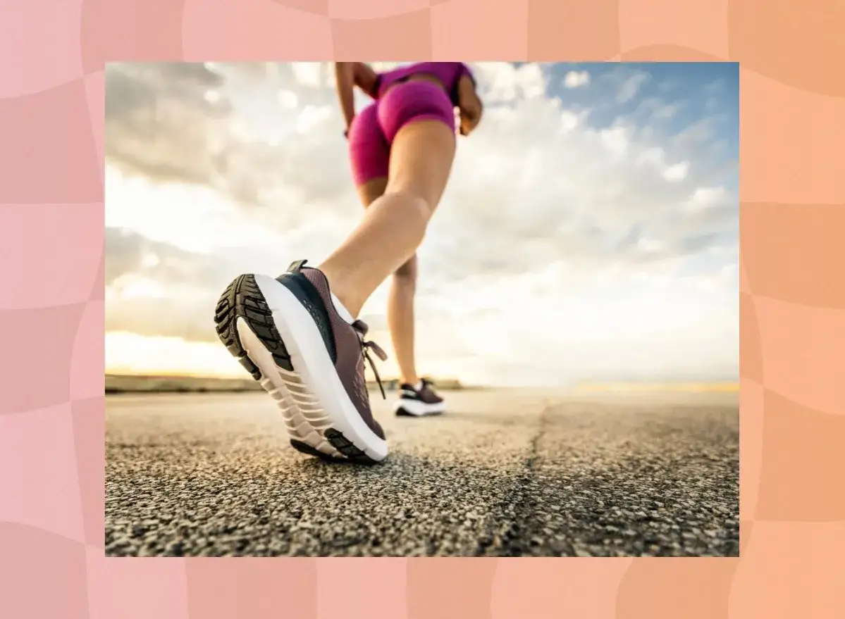 Beine in pinken Shorts und Laufschuhen beim Power Walking auf einer Straße bei Sonnenuntergang.