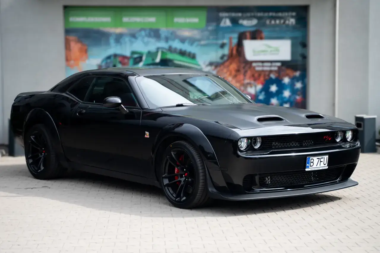 Czarny Dodge Challenger SRT z czerwonymi zaciskami hamulcowymi i felgami, gotowy do jazdy.