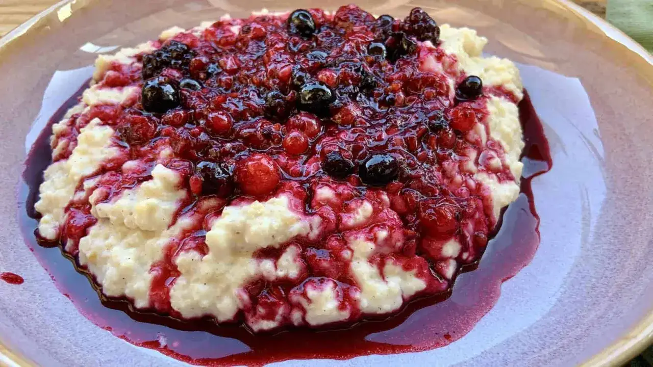 Cremiger Hirsebrei, gekocht und serviert mit einem üppigen Topping aus roten und blauen Beeren, die in ihrem eigenen Saft glänzen. Ein Genuss!