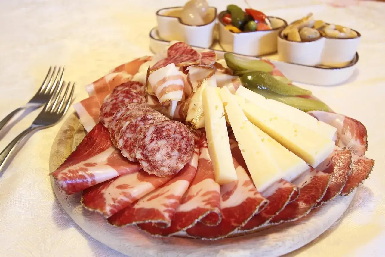Bei taglieri con un assortimento di salumi e formaggi, accompagnati da cetriolini e altre delizie.