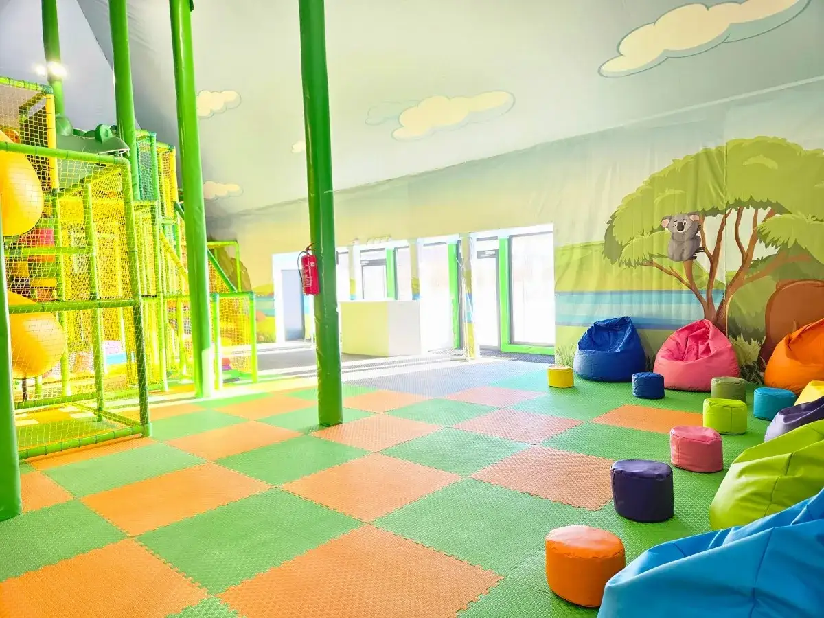 Kolorowy plac zabaw w Sławut&oacute;wko Park Ewolucji z miękkimi siedziskami i wielopoziomową konstrukcją zachęca do zabawy.