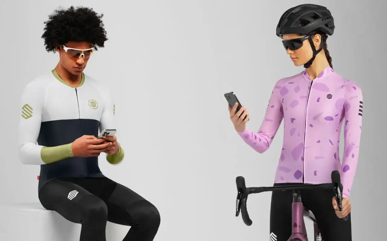 Para rowerowa, mężczyzna i kobieta w strojach kolarskich sprawdzają Strava na telefonach.