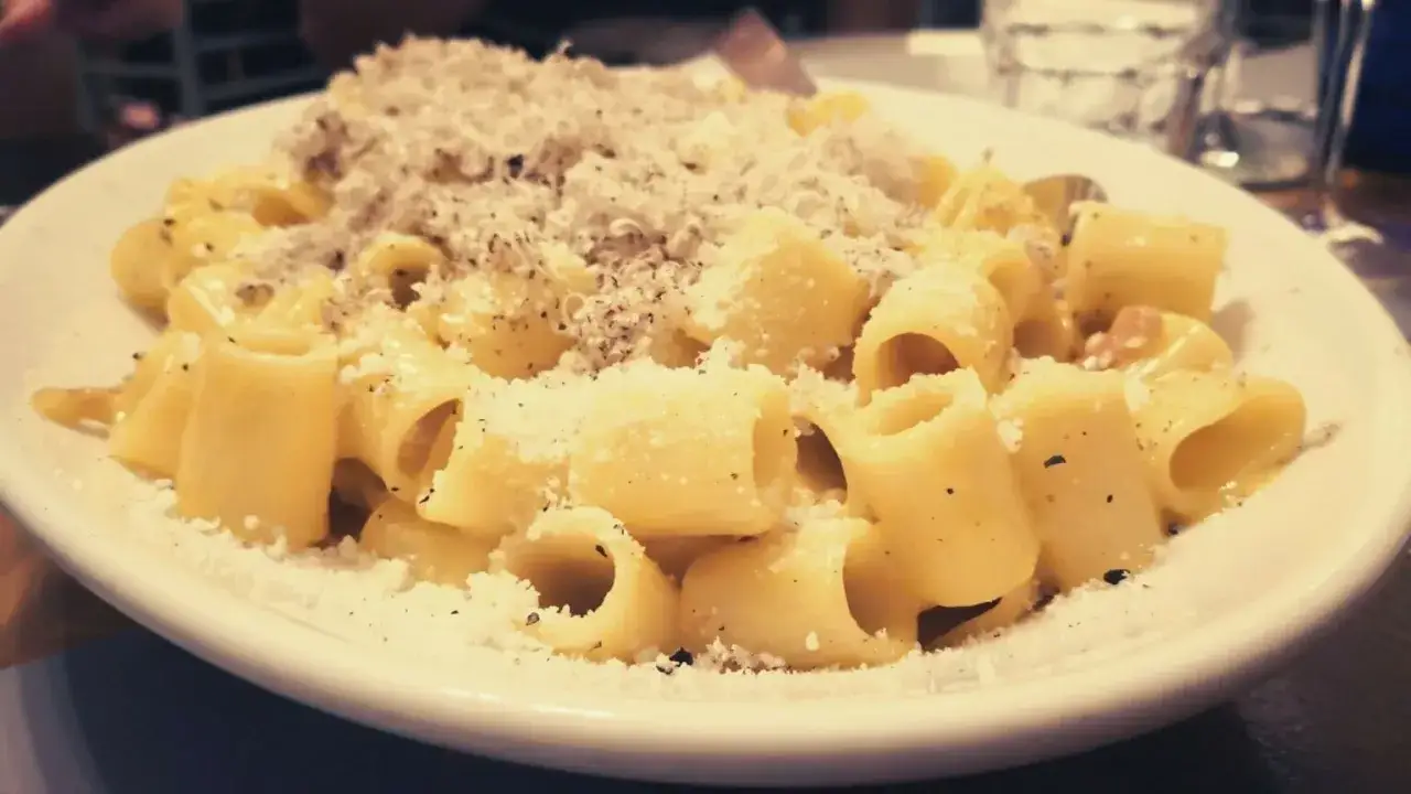 En krämig carbonara med rigatoni, rikligt toppad med parmesan och svartpeppar. Perfekt vin till carbonara.