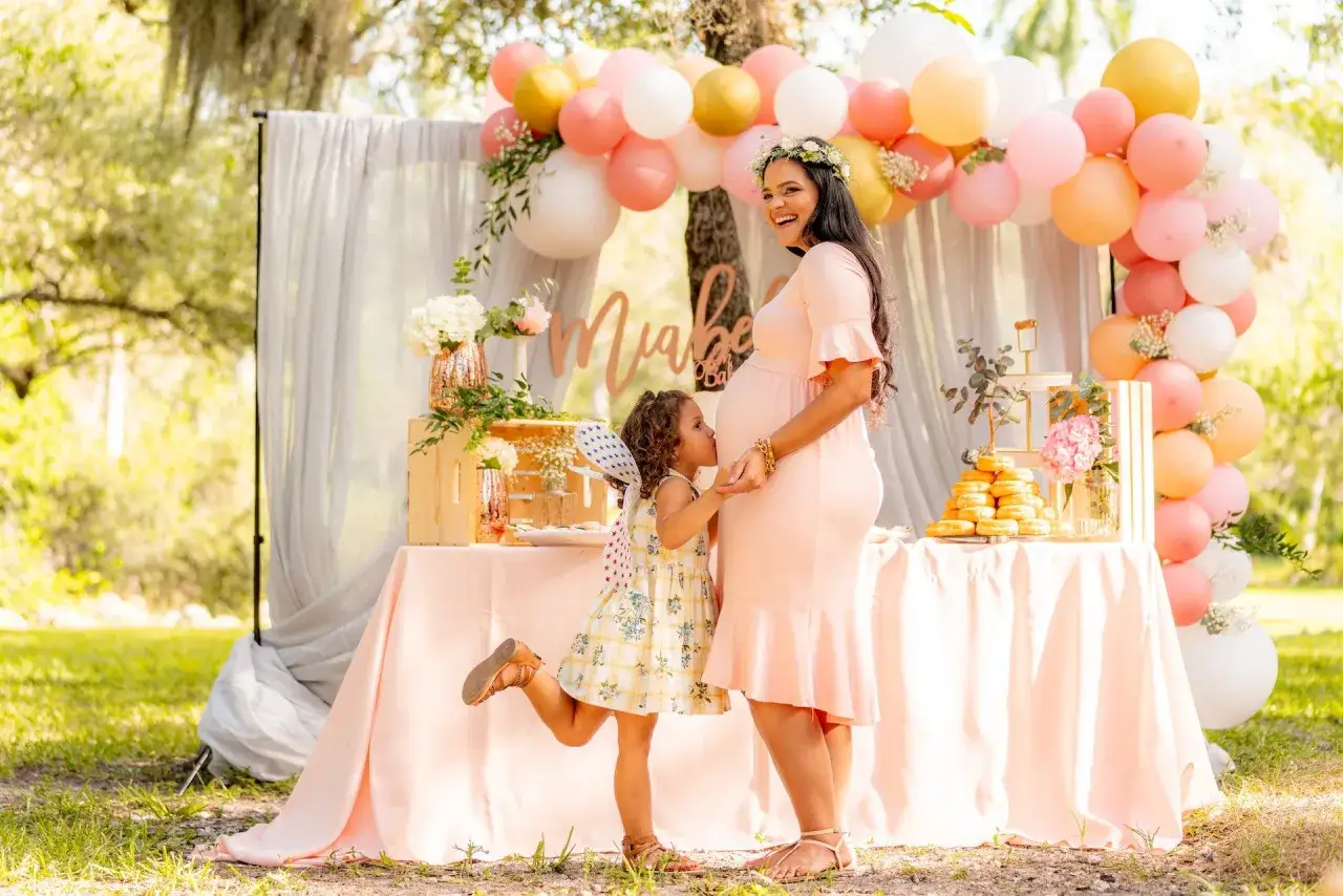 Uroczyste baby shower z balonami i słodkościami. Widać, kto organizuje baby shower – przyszła mama i jej córeczka.