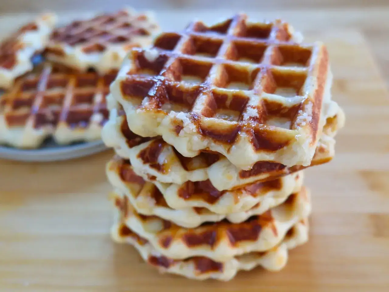 Una pila di waffle croccanti, con la loro **waffle ricetta originale belga**, spolverati di zucchero.