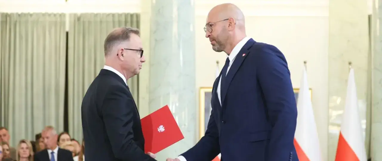 Minister sportu wręcza dokument.