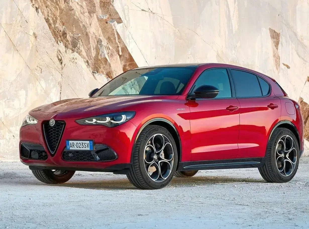 Czerwone Alfa Romeo Stelvio na tle skalnej ściany. Sprawdź aktualną alfa romeo stelvio cena i wybierz swój wymarzony SUV.