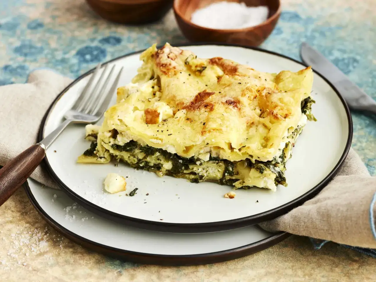 Ein Stück Spinatlasagne mit Käse überbacken, bereit zum Genießen. Dieses Spinatlasagne Rezept ist ein Genuss!