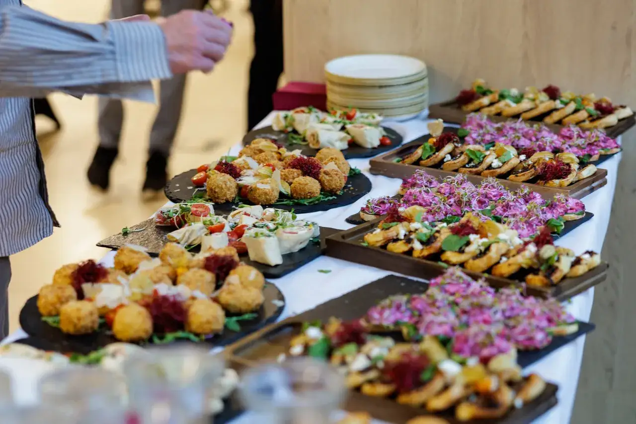 Elegancki catering na Boże Narodzenie: stoły uginają się od wykwintnych przekąsek, takich jak kulki serowe, roladki i bruschetty.