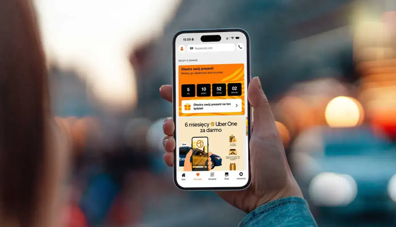 Dłoń trzyma smartfon z aplikacją Orange. Na ekranie widać odliczanie do otwarcia prezentu. Chcesz wiedzieć, jak sprawdzić ile mam internetu w Orange? Ta aplikacja może pomóc!