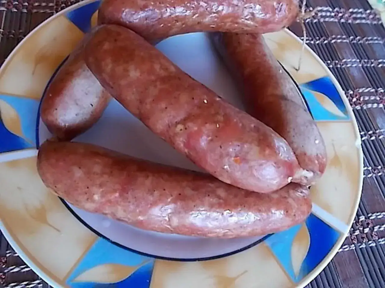 Gotowe do wędzenia kiełbaski na talerzu. Wkrótce dowiesz się, jak wędzić kiełbasę w wędzarni, by uzyskać ten smak.