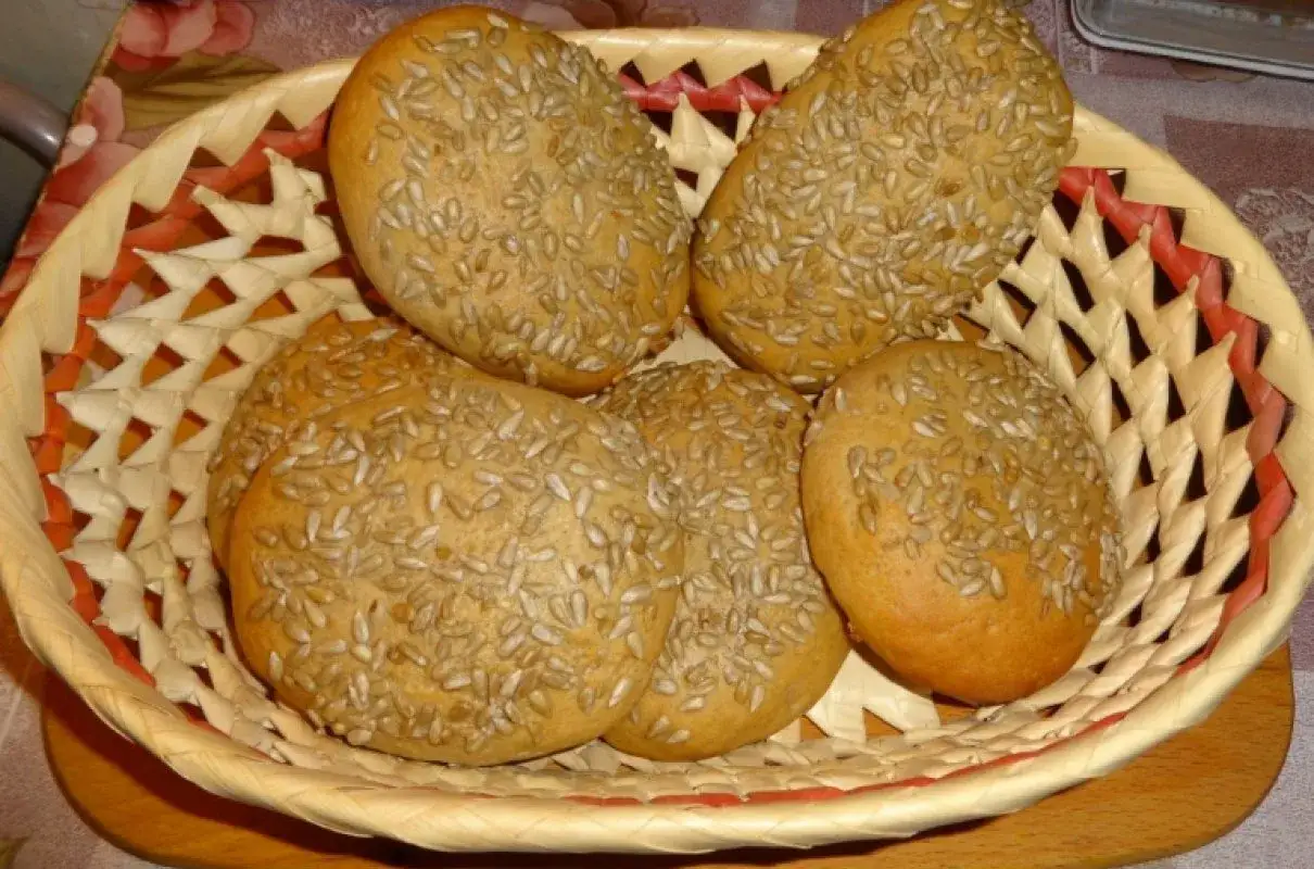 Koszyk pełen świeżych bułeczek z mąki żytniej, posypanych słonecznikiem. Idealne na śniadanie.