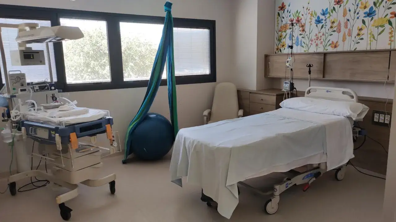 Habitaci&oacute;n de parto con cuna neonatal, cama, bal&oacute;n de pilates y hamaca. Averiguar cuanto cuesta un parto en Espa&ntilde;a es clave para planificar.