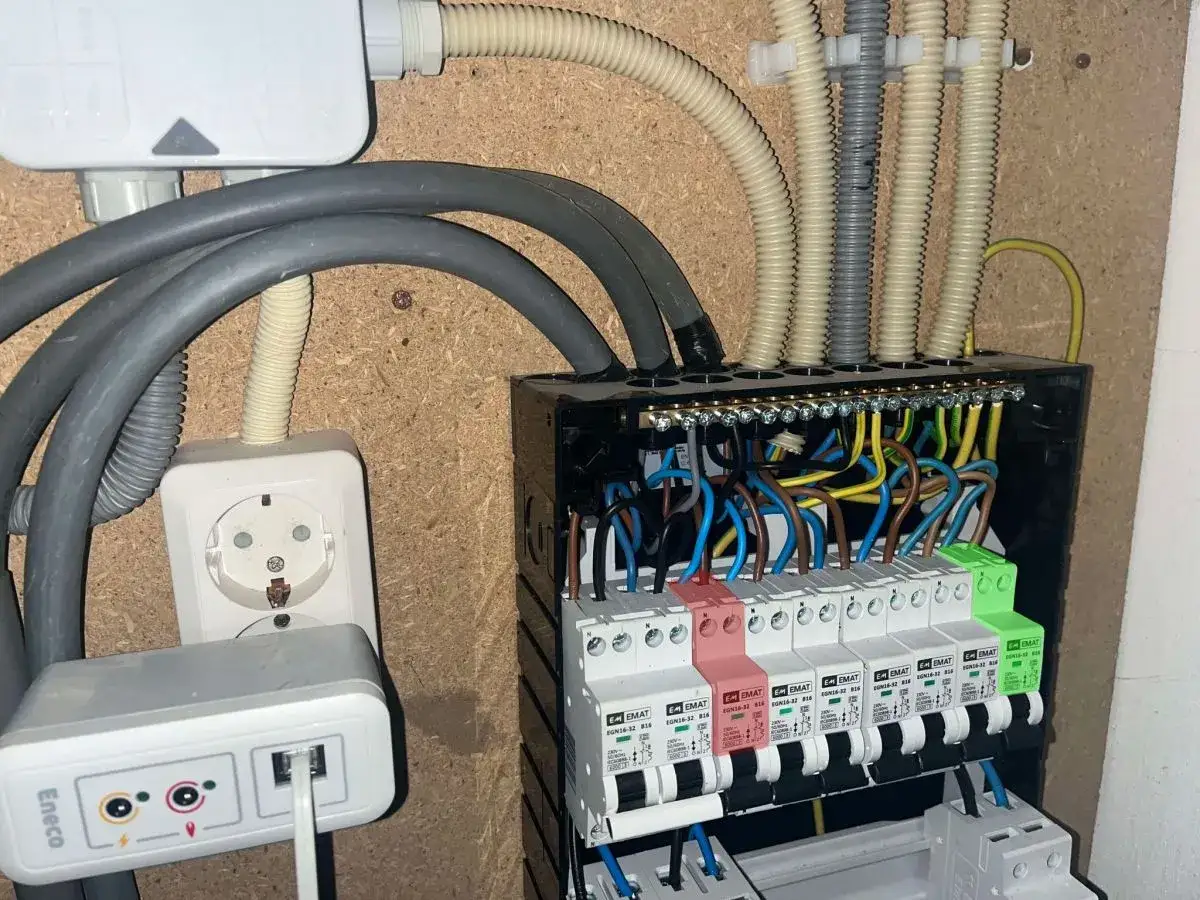 Instalacja elektryczna z widocznym rozdzielaczem, gniazdkiem i przewodami. Dowiedz się, jak włączyć prąd w skrzynce, aby wszystko działało poprawnie.