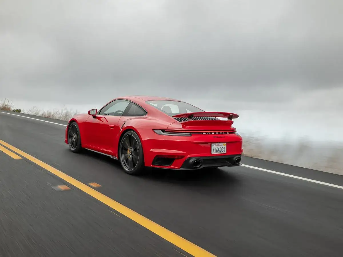 Roter Porsche Turbo S auf nasser Straße, bereit für den 0-100 Sprint.