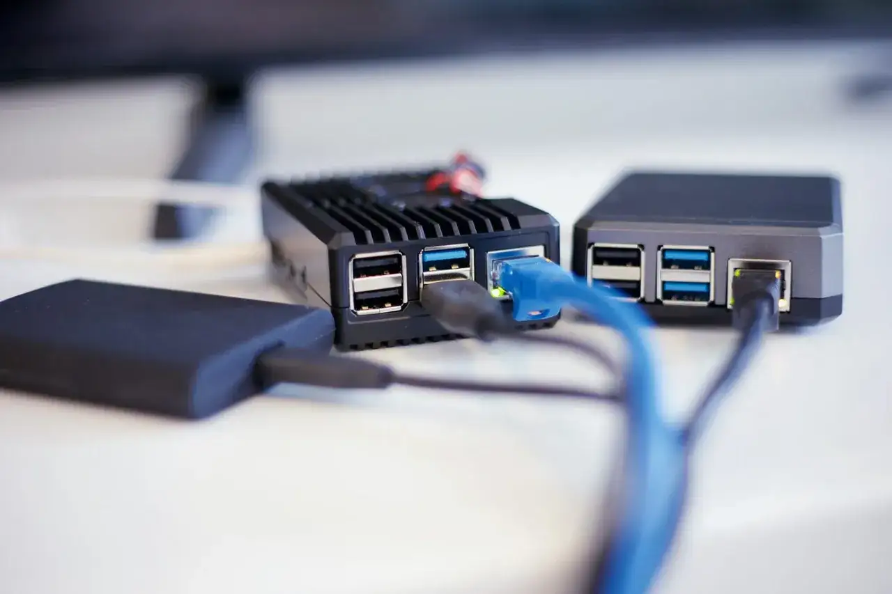 Tv&aring; Raspberry Pi-enheter med n&auml;tverkskablar och en extern h&aring;rddisk anslutna. En perfekt setup f&ouml;r en hemmabyggd raspberry pi nas.
