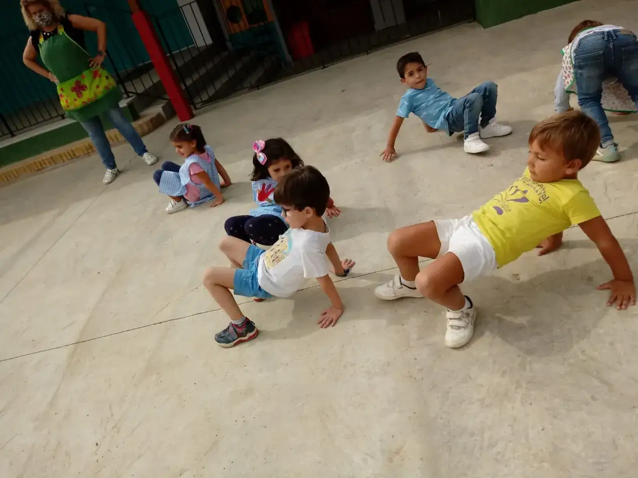 Niños aprendiendo que es la psicomotricidad infantil, moviéndose en el suelo.