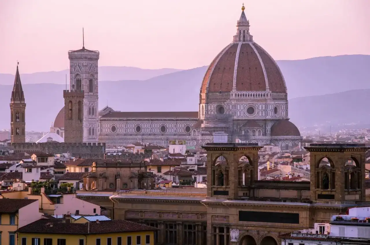Widok na katedrę Santa Maria del Fiore we Florencji o zachodzie słońca, z kopułą Brunelleschiego górującą nad miastem.