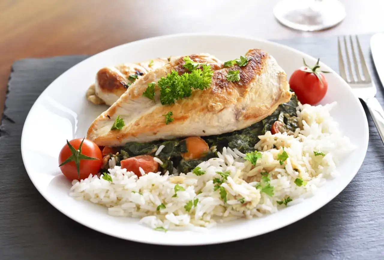 Idealny pomysł na obiad fit: grillowana pierś kurczaka z ryżem, szpinakiem i pomidorkami koktajlowymi.