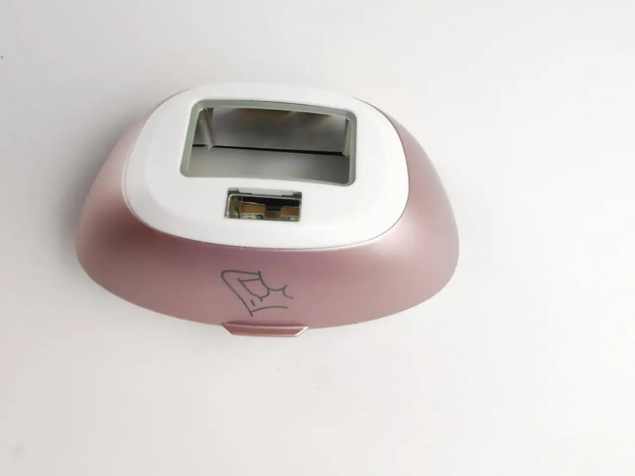 Różowy korpus depilatora Philips Lumea 9900, z wycięciem na okienko i subtelnym rysunkiem ramienia. Wiele osób szuka philips lumea 9900 opinie.