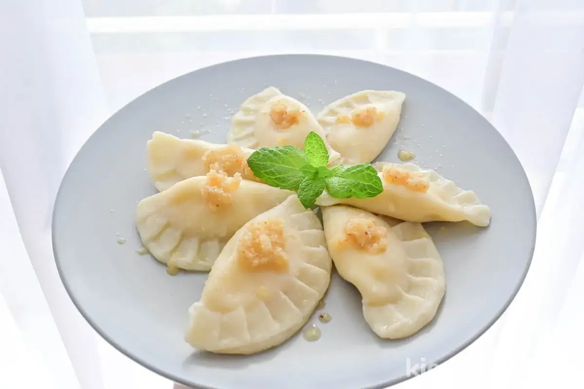 Pyszne pierogi z serem na słodko, udekorowane miętą, kuszą swoim wyglądem. Idealne na deser lub śniadanie.