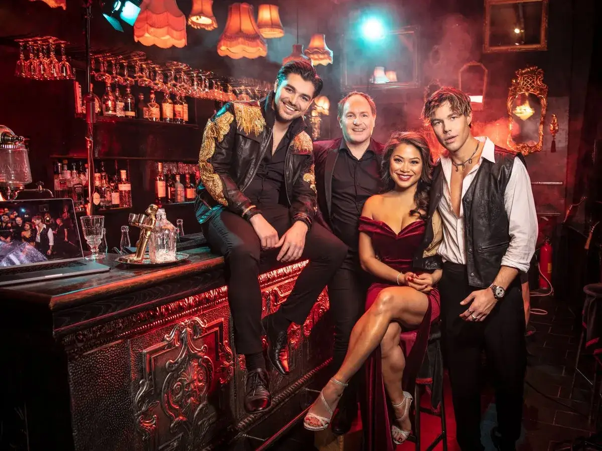 Anton Ewald och vänner poserar vid en bar i Moulin Rouge-stil.