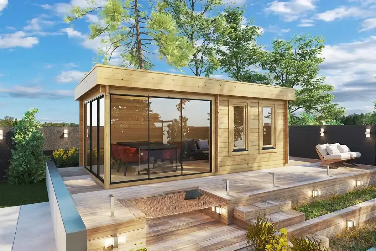 Une extension veranda moderne en bois avec de grandes baies vitr&eacute;es, am&eacute;nag&eacute;e avec une table et des fauteuils rouges, et un salon ext&eacute;rieur.