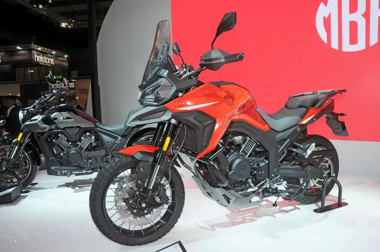 Pomarańczowy motocykl Morbidelli T1002VX na wystawie, gotowy na przygodę. Obok stoi jego szary brat.
