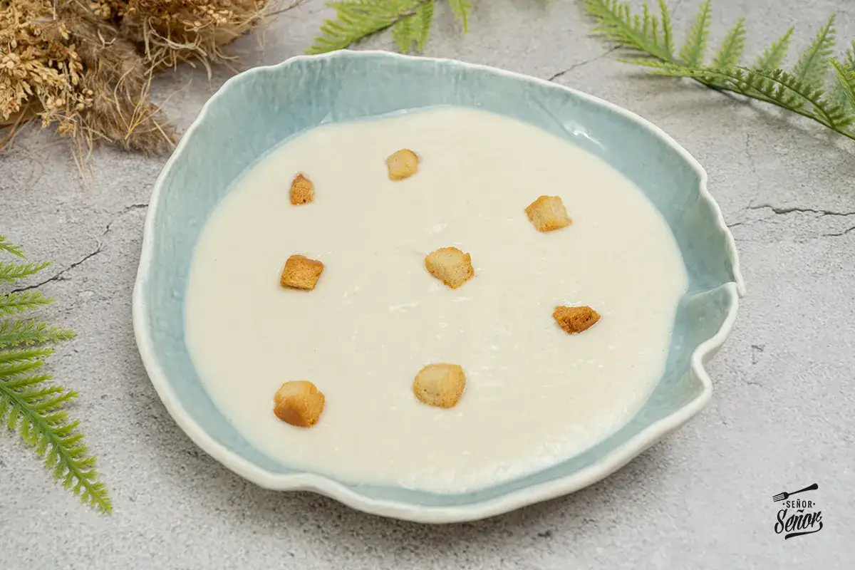 Crema de coliflor suave y cremosa, adornada con picatostes crujientes. Un plato reconfortante y delicioso.