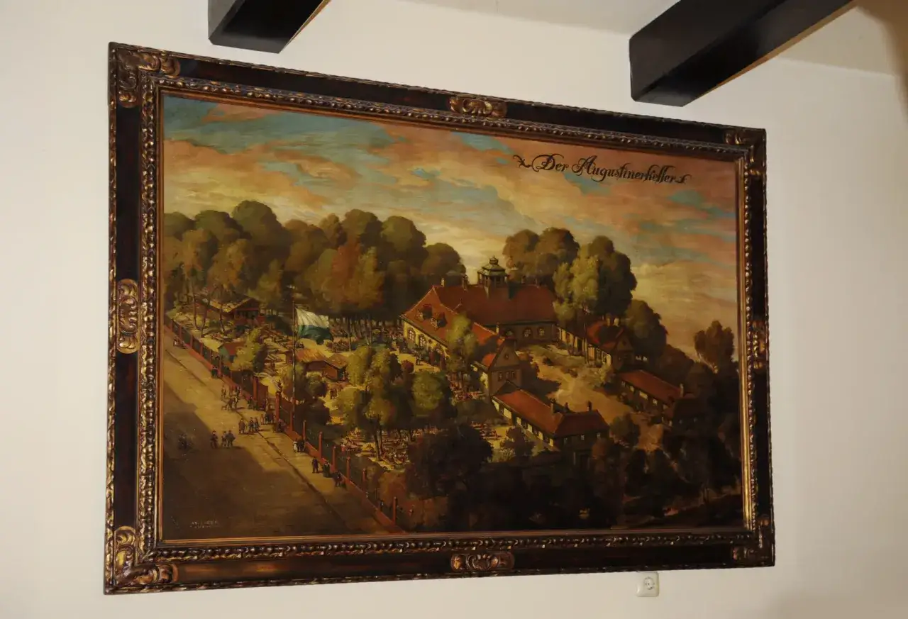 Gem&auml;lde von Josef Wagner: Der Augustinerkeller mit vielen Menschen, B&auml;umen und Geb&auml;uden unter einem dramatischen Himmel.