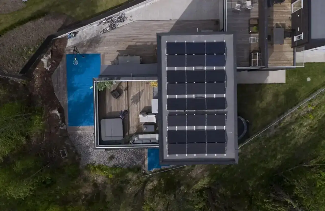 Tak, to jest idealne miejsce, by lagra solel. Modern hus med solpaneler p&aring; taket, pool, utem&ouml;bler och cyklar.