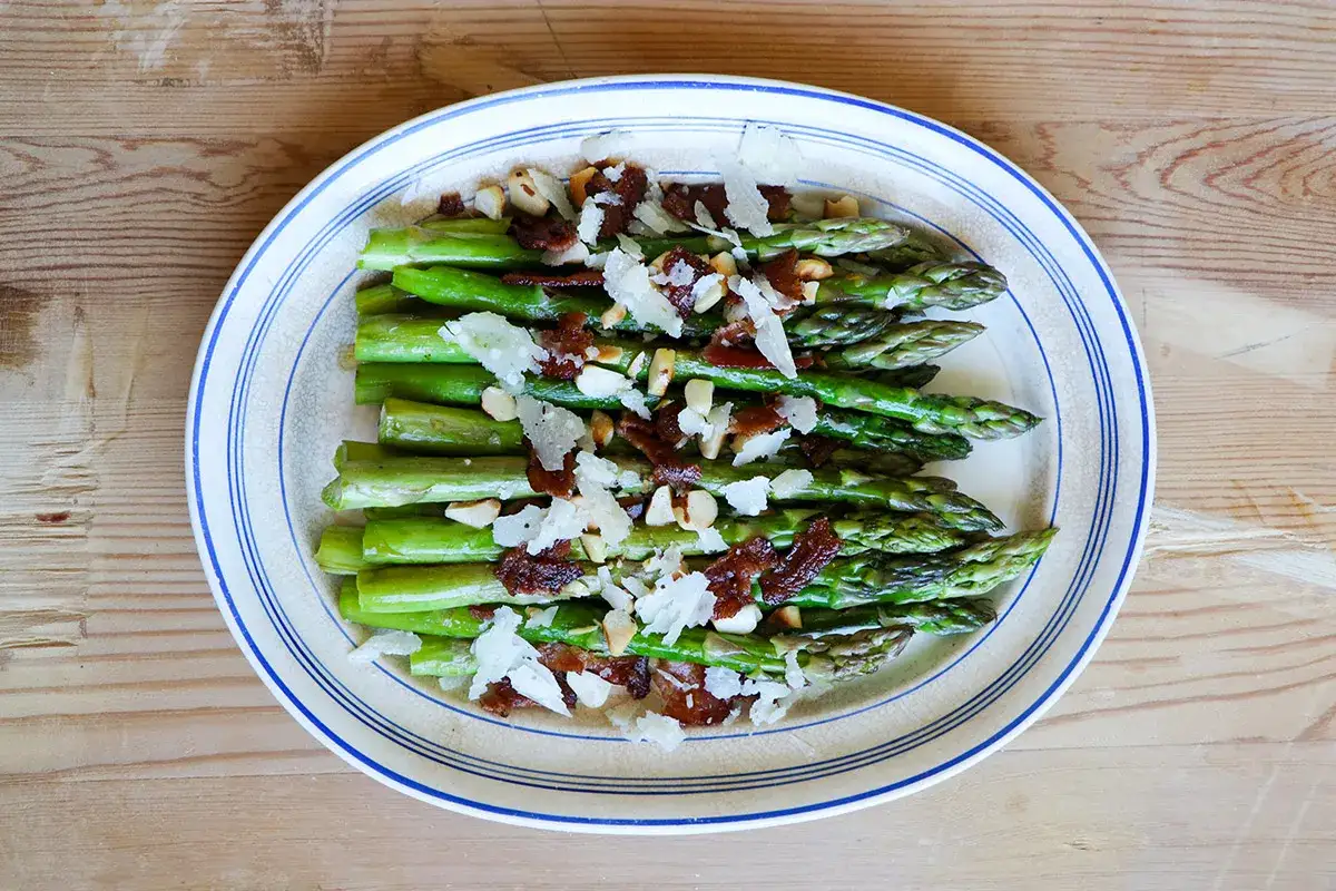 Grön sparris med knaprigt bacon, nötter och parmesan. En härlig rätt med baconlindad sparris som passar till det mesta.