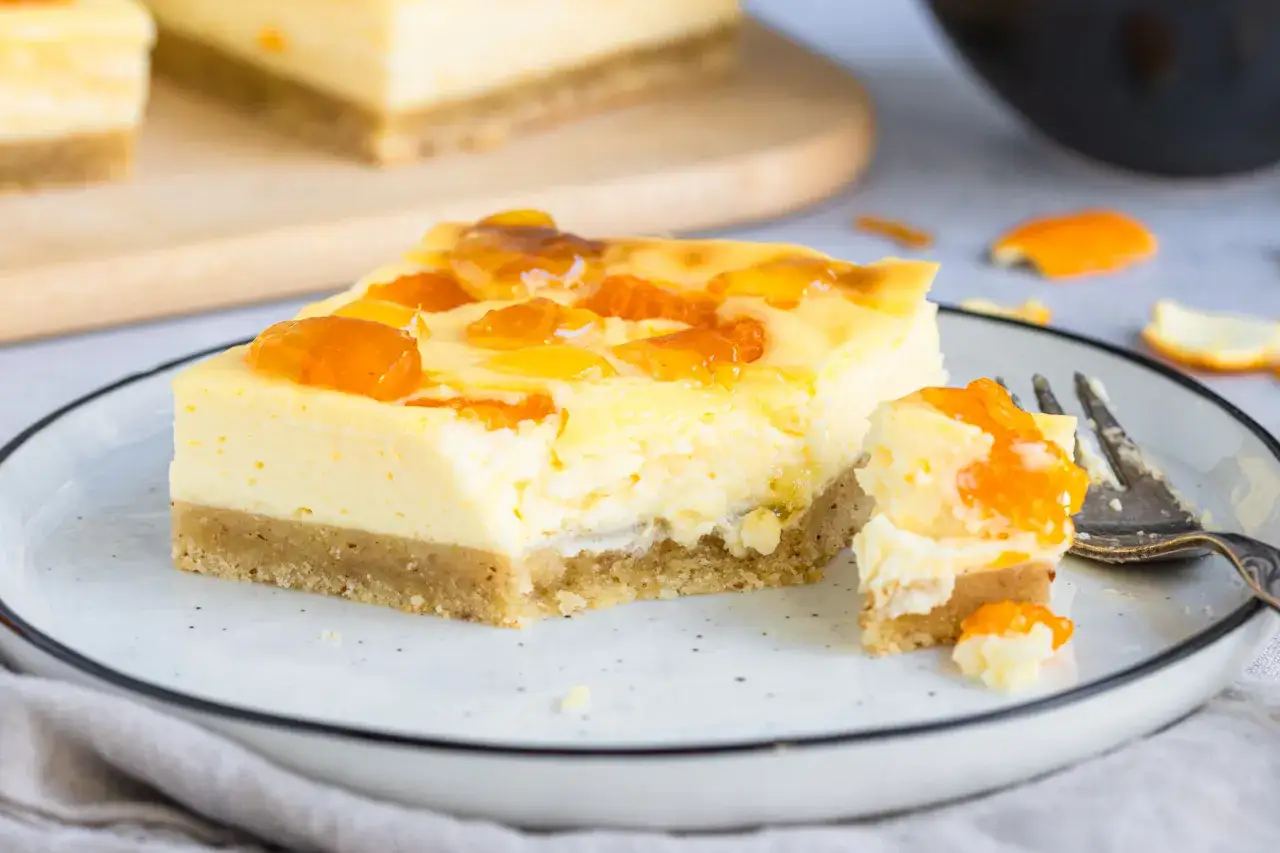 Ein Stück saftiger faule weiber kuchen mit Mandarinen-Gelee-Topping auf einem Teller.