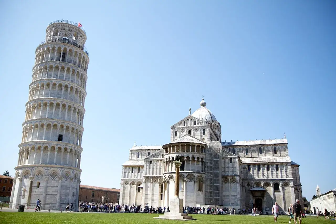 Torre de Pisa y la Catedral, ic&oacute;nicos monumentos de Italia, bajo un cielo azul.