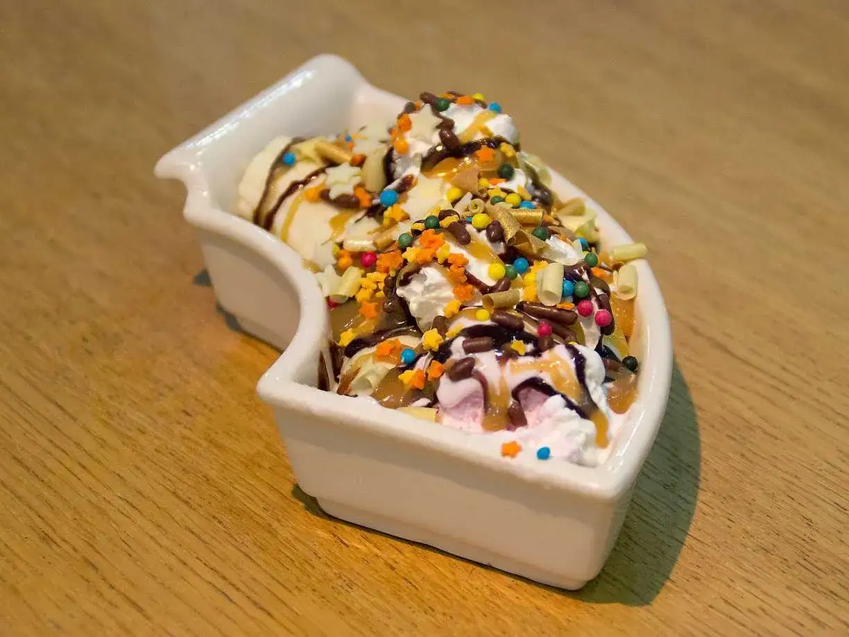 En h&auml;rlig banana split med glass, gr&auml;dde, choklads&aring;s och f&auml;rgglada str&ouml;ssel.