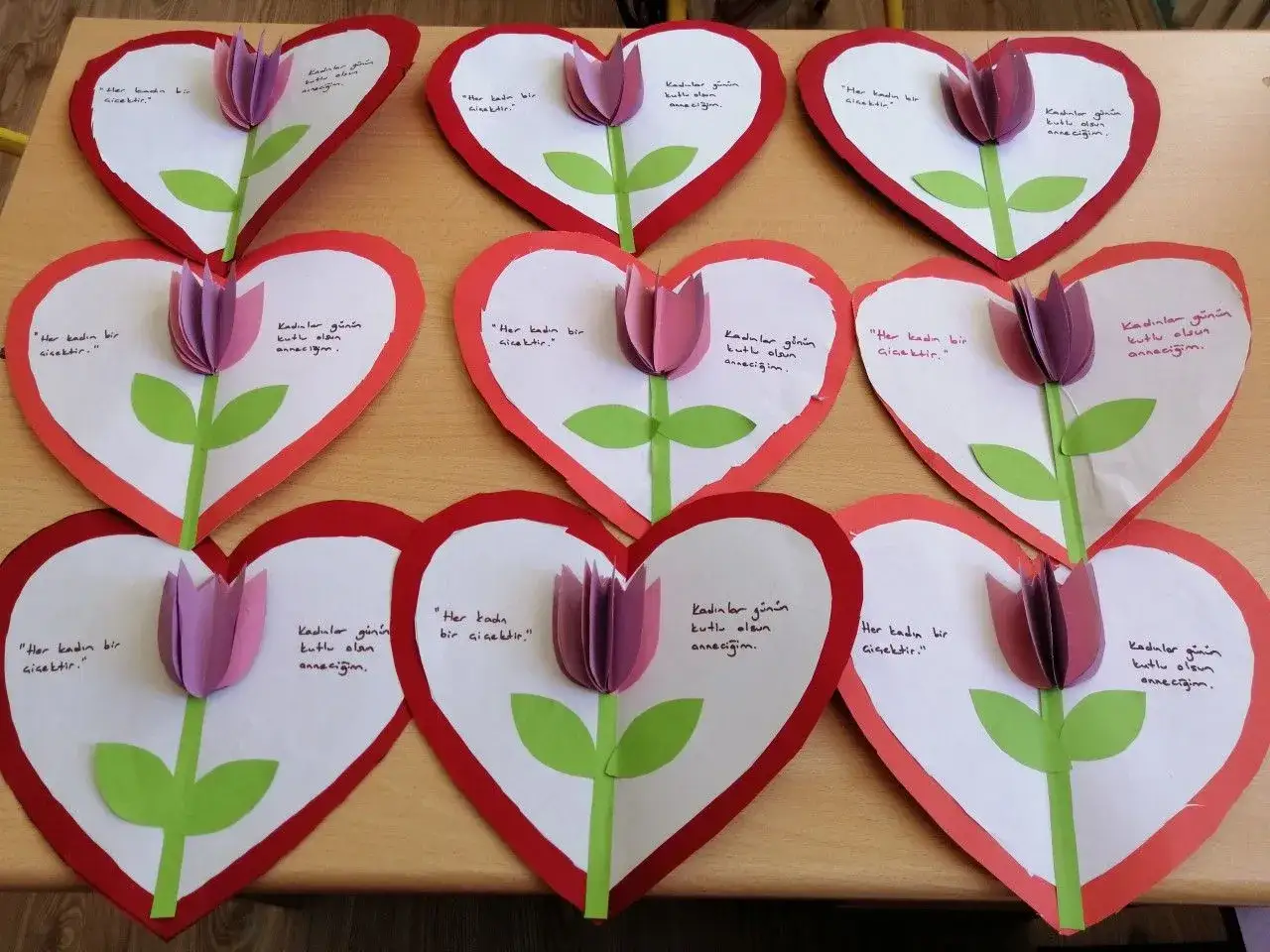 Manualidades de **actividades día de la madre**: corazones de papel con tulipas y mensajes.
