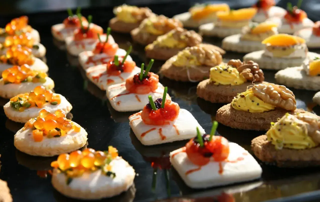 Varietà di finger food da fare in anticipo: tartine con salmone, gamberetti, uova di pesce e noci. Perfetti per ogni occasione.