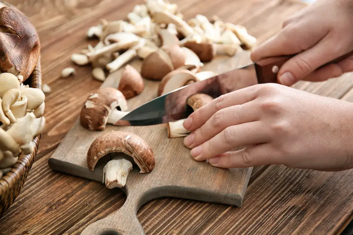 Krojenie pieczarek na desce. Niskie pieczarki kalorie to zdrowa przekąska.