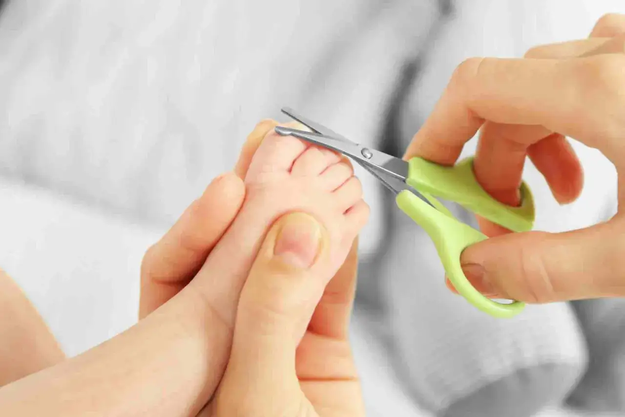 Mani delicate tagliano le unghie di un neonato. &Egrave; importante sapere quando si possono tagliare le unghie ai neonati per la loro sicurezza.