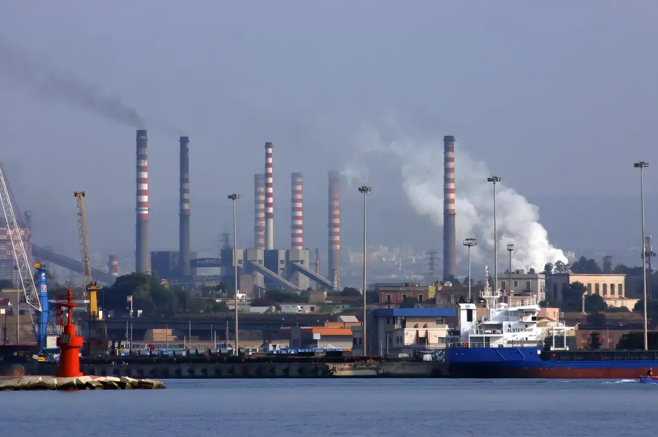 Dymiące kominy fabryki i port z dźwigami. Czy stal zdrożeje?