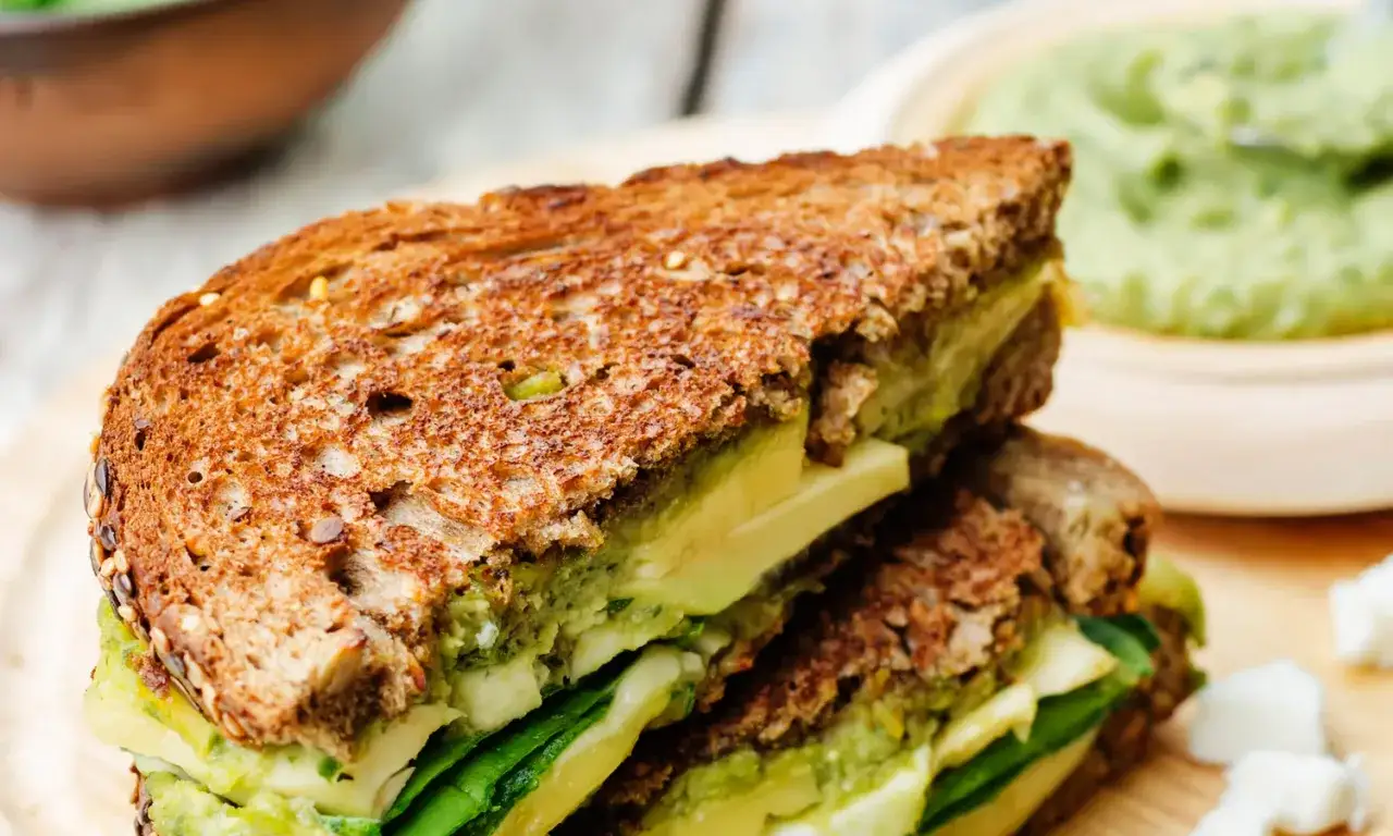 Pyszny sandwich z chlebem tostowym pełnoziarnistym, awokado i szpinakiem.