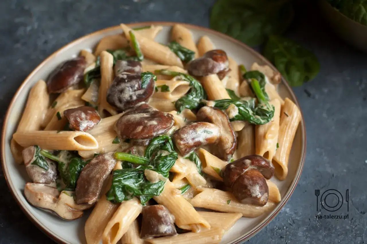 Penne z kremowym sosem, szpinakiem i aromatycznymi potrawami z grzybów. Pyszne danie, które zachwyci każdego miłośnika grzybów.