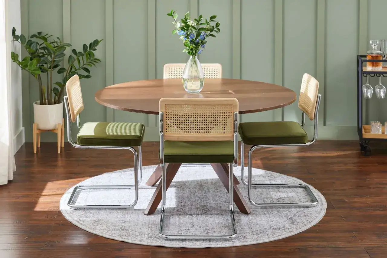 A round wooden table with cane-backed chairs, perfect for a stylish dining room. Learn how to choose a dining room table that fits your space.