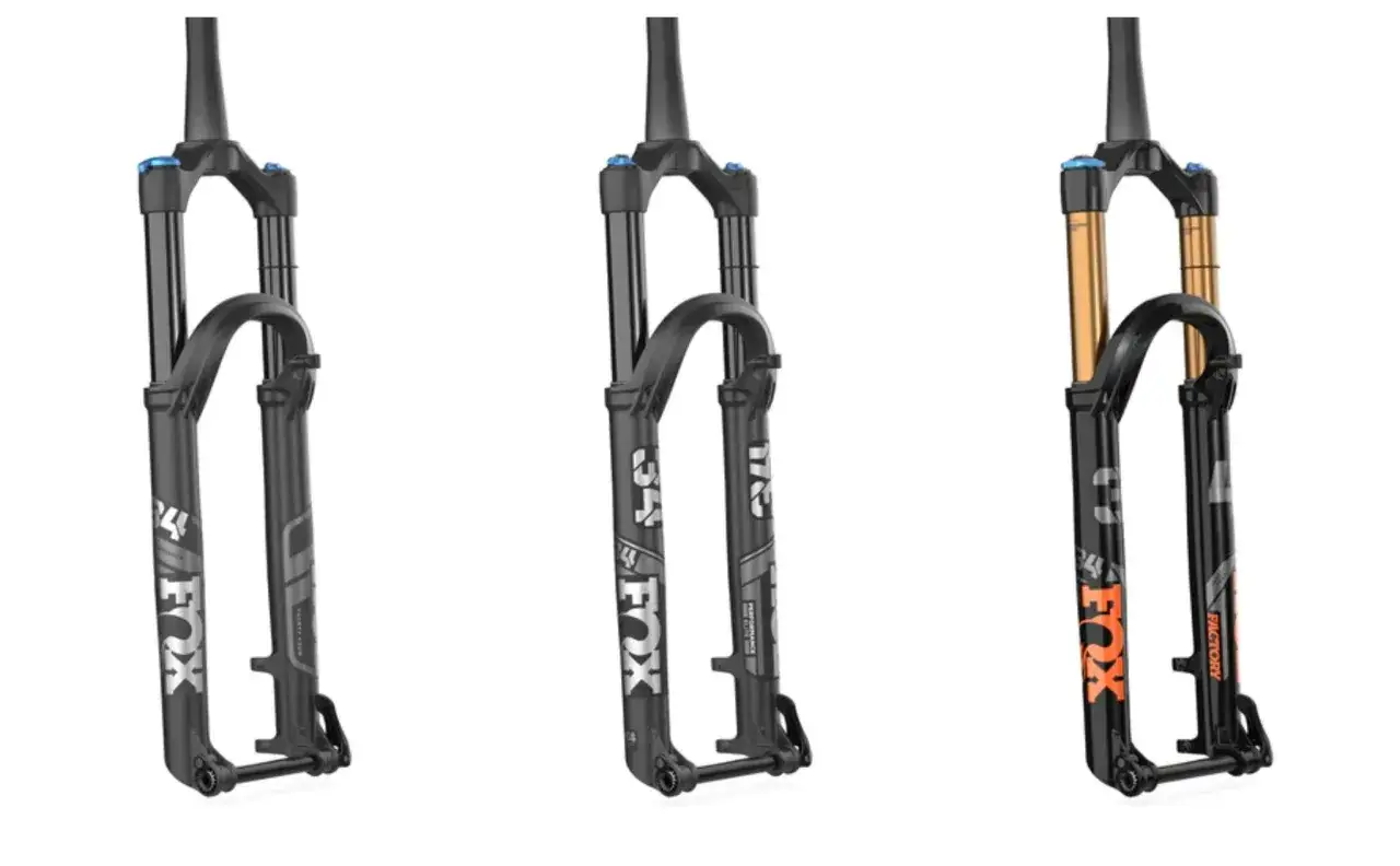 Three Fox bike forks: two black Performance models and one black and gold Factory model, showcasing the difference between Fox Factory vs Performance.
