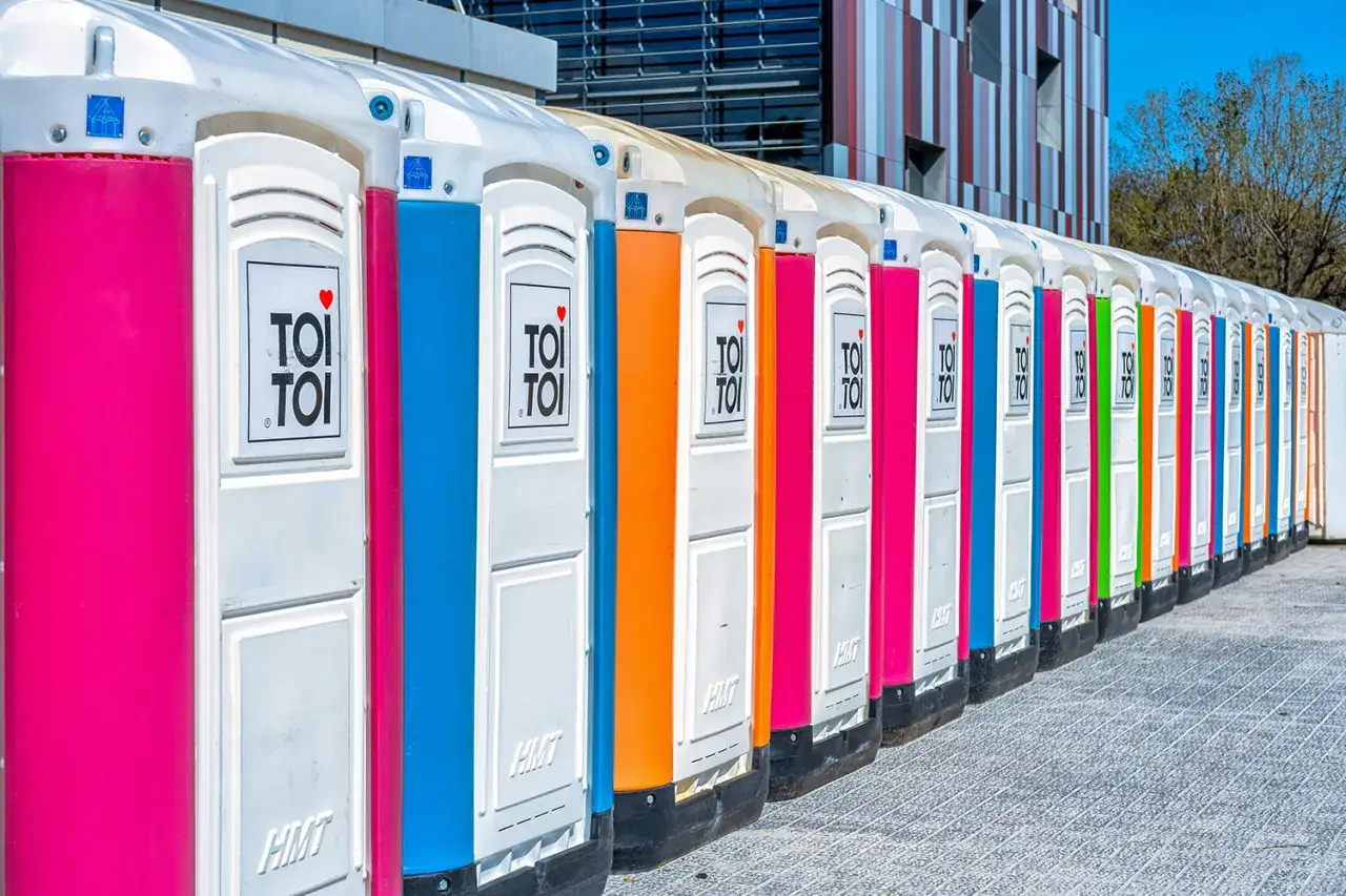 Kolorowe toalety przenośne ustawione w rzędzie, idealne na działkę. Projekt