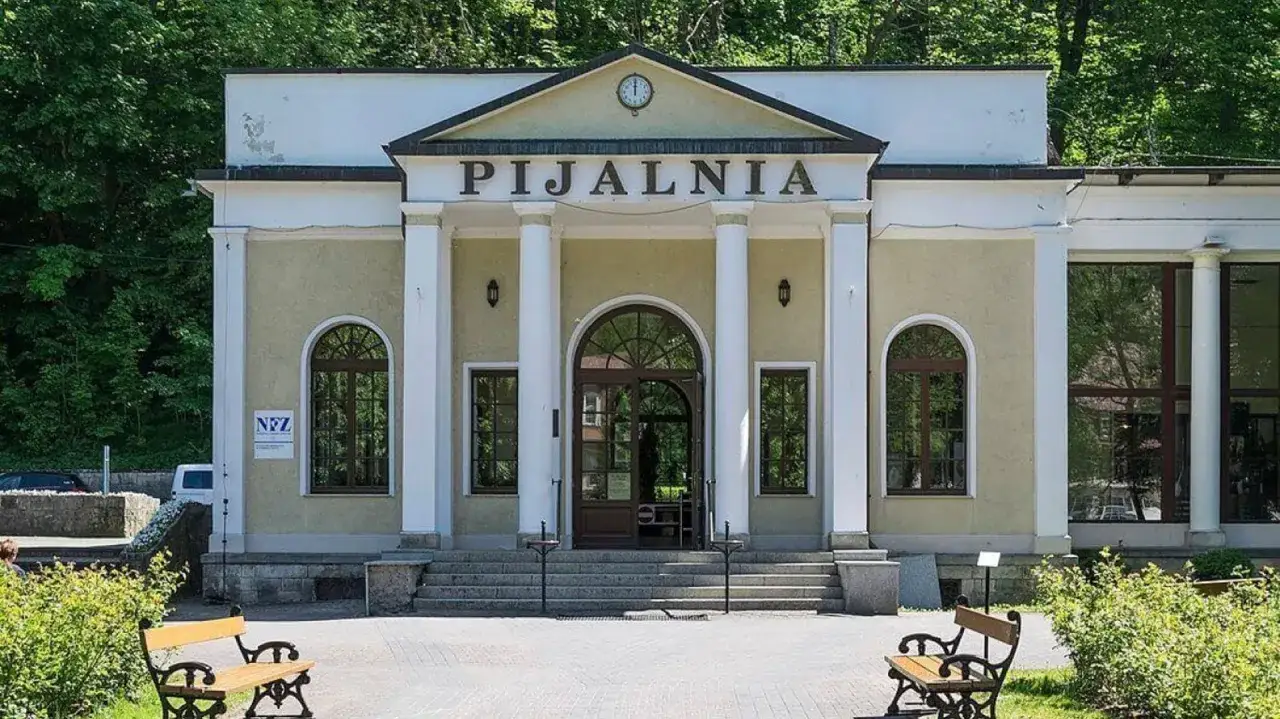 Pijalnia wód w Dusznikach Zdroju, z kolumnami i łukowymi oknami, zaprasza do odpoczynku.