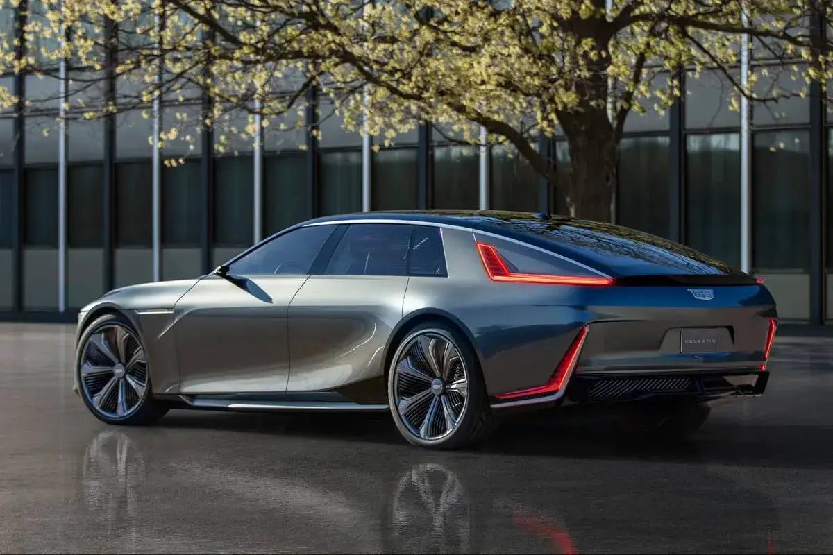 Elegancki, szary Cadillac Celestiq z futurystycznymi światłami LED, przypominający designem Polestar 2, stoi na mokrej nawierzchni.