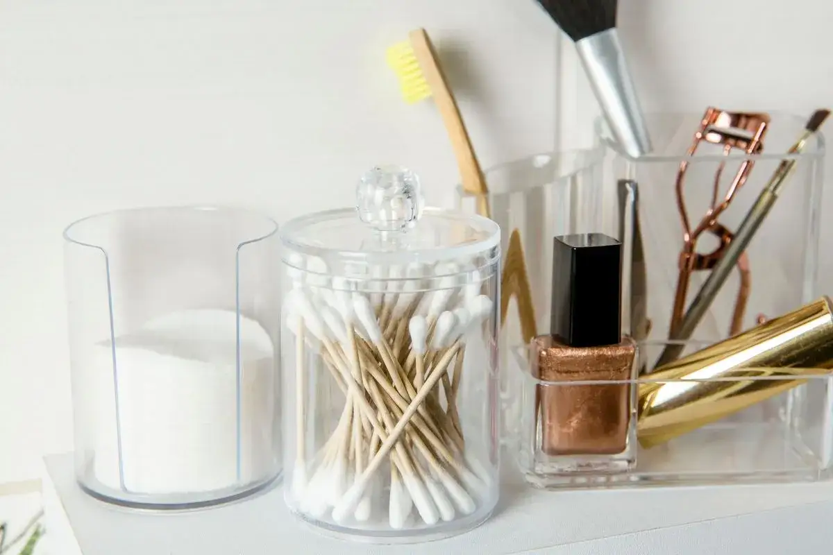 Des cotons, des cotons-tiges et des produits de maquillage dans des contenants transparents. Id&eacute;al pour savoir o&ugrave; jeter les produits de maquillage usag&eacute;s.