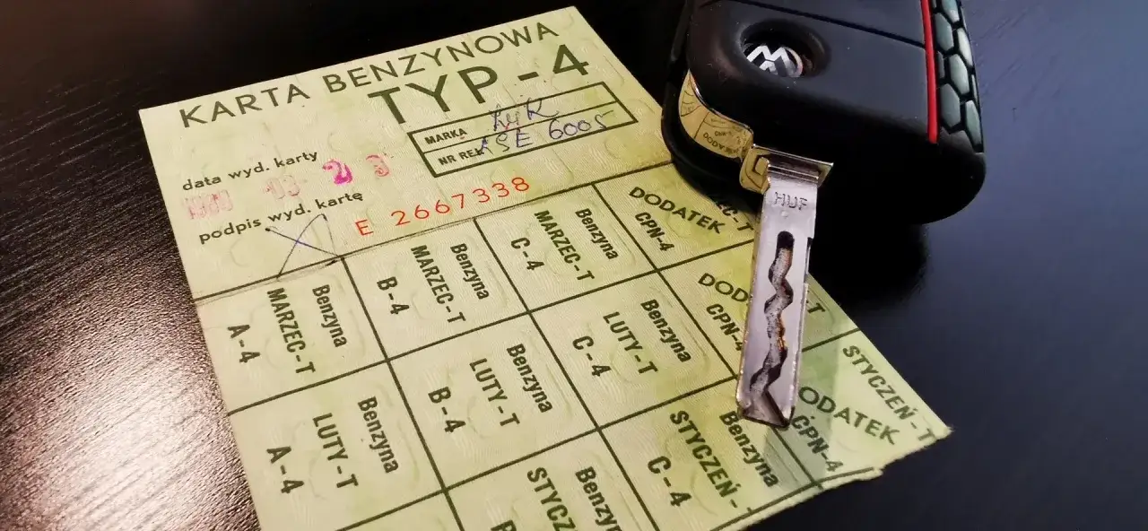 Karta paliwowa z PRL-u, talon na benzynę, obok kluczyk samochodowy.