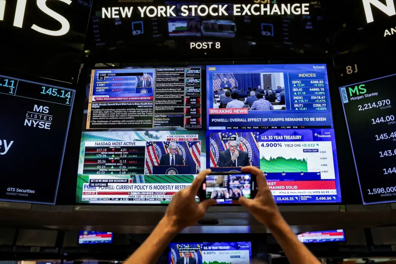 Ekran giełdy pokazuje akcje rynku amerykańskiego, w tym dane z NYSE i NASDAQ, z nagł&oacute;wkami o polityce Fed i wpływie ceł.